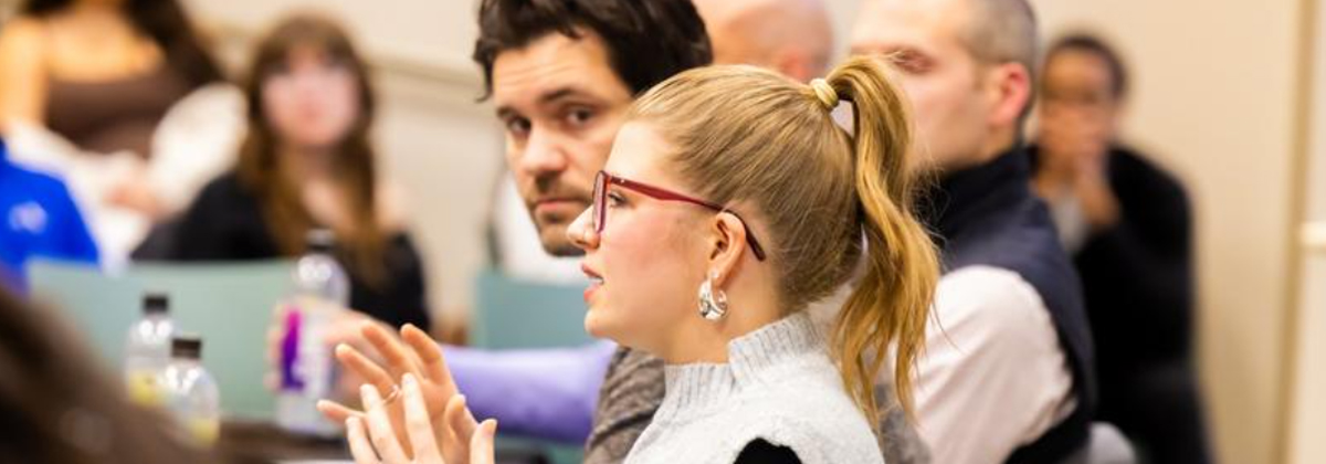 Instructor teaching students in a classroom with presentation on a screen